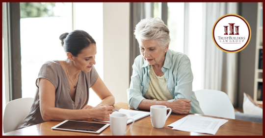 Two women sitting at a table looking at paperwork